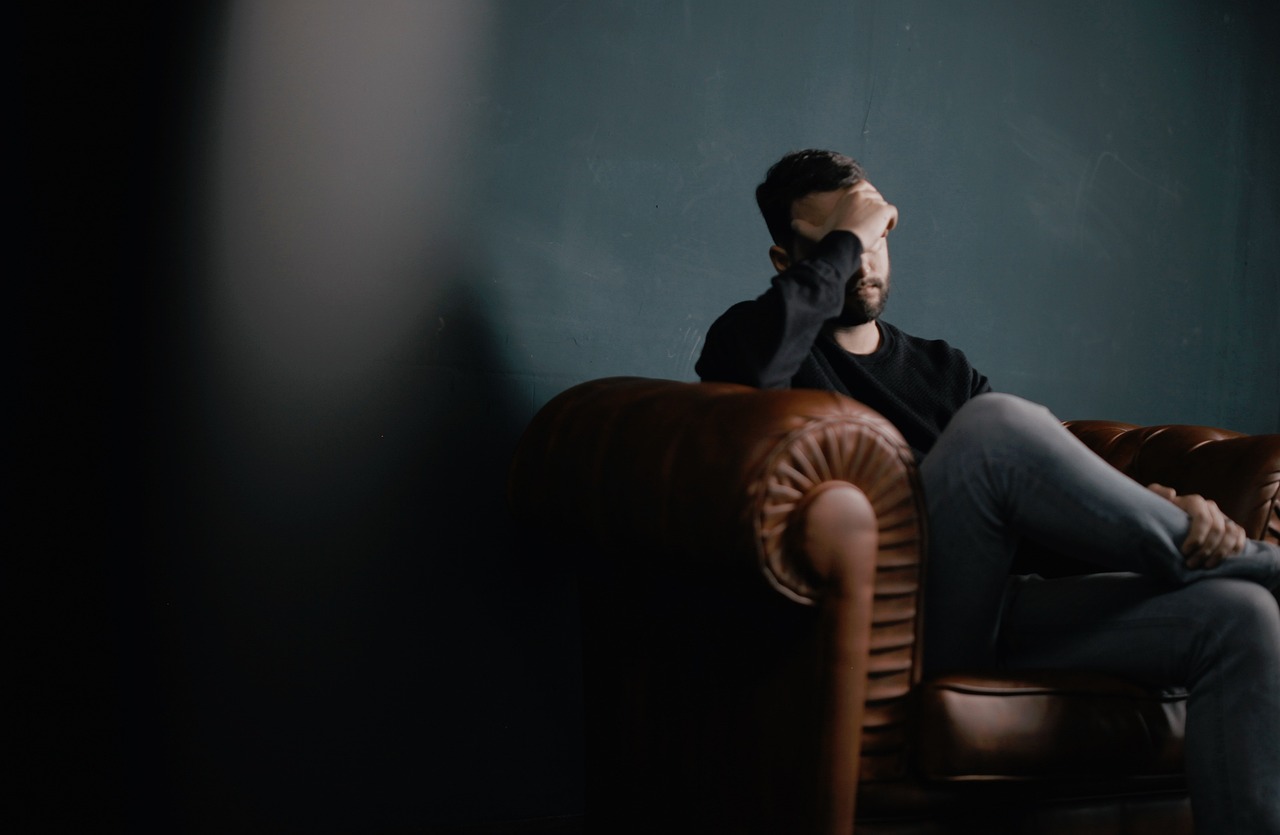 Person sitting alone appearing emotionally exhausted